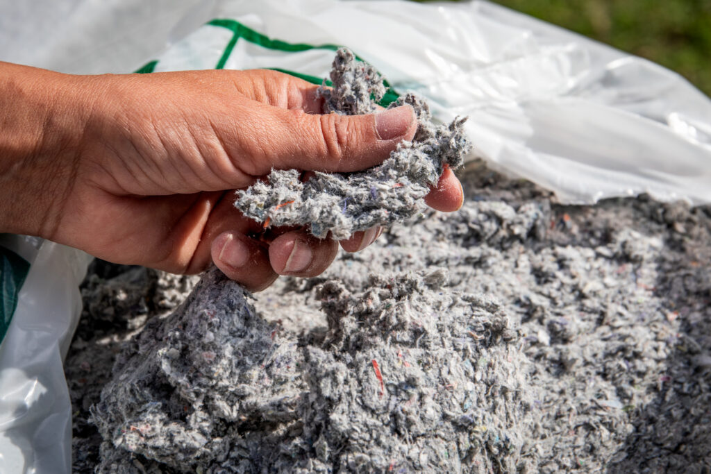 A person pickup up loose-fill cellulose insulation